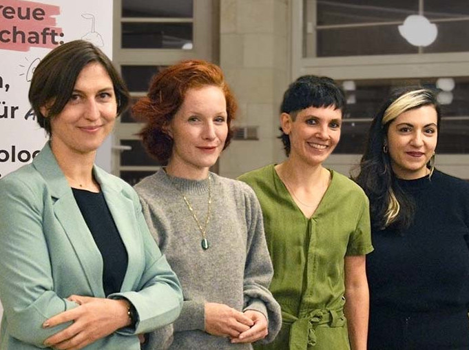 Die Gäste der Podiumsdiskussion auf der Bühne vor einem Banner des Konzeptwerks
