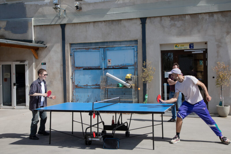 Zwei Personen spielen Tischtennis im Freien